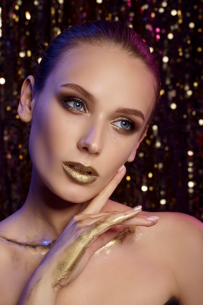 Portrait of beautiful woman with golden makeup