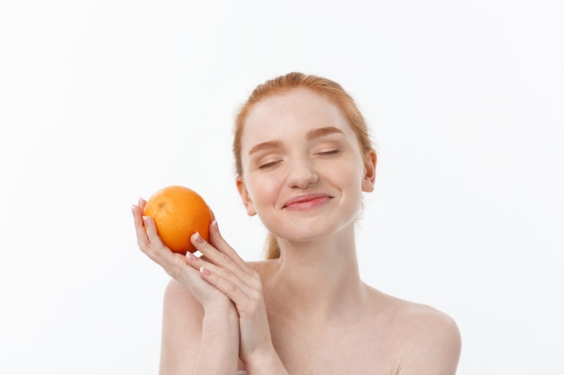 Portrait beautiful woman with a orange isolated.