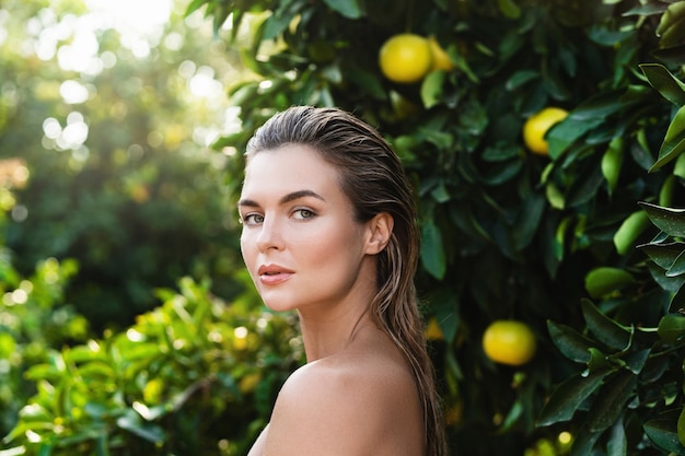 Portrait of beautiful woman with smooth skin against lemon trees