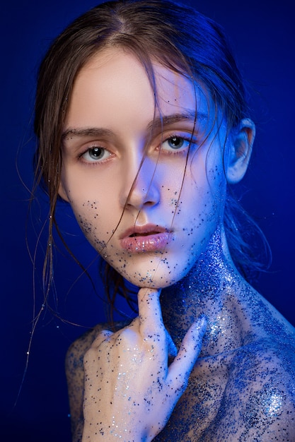 Portrait of beautiful woman with sparkles on her face.