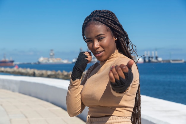 Portrait of beautiful young afro american woman , with bandages on her hands to practice martial arts, boxing.