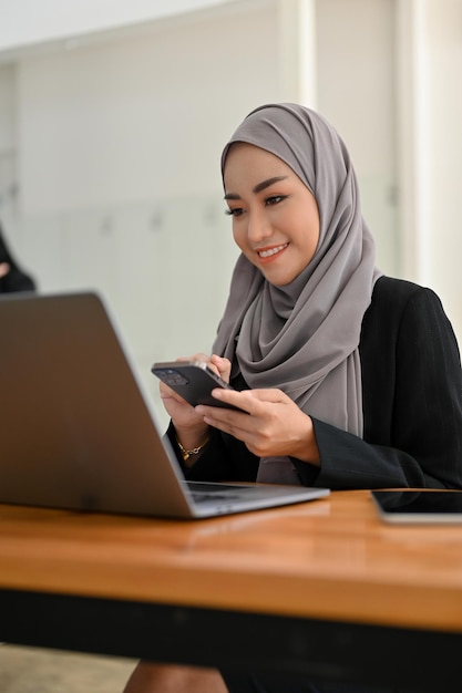 Portrait of a beautiful young Asian Muslim businesswoman at her office desk