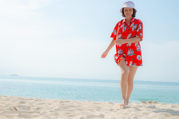 Portrait beautiful young asian woman relax walking leisure around sea beach ocean with white cloud on blue sky in travel vacation