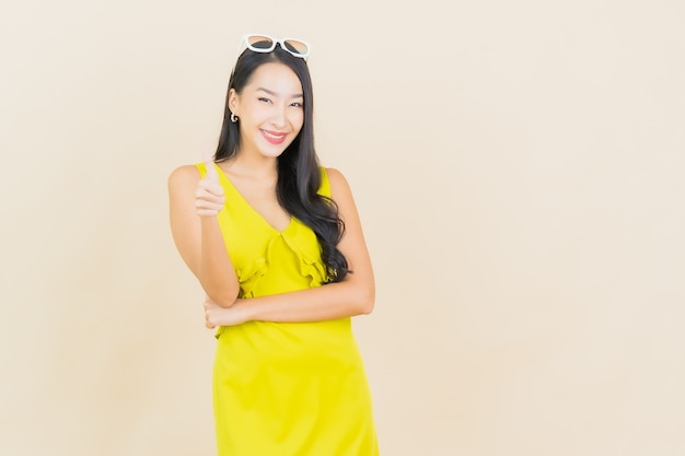 Portrait beautiful young asian woman smile with action on cream wall