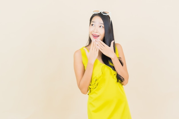 Portrait beautiful young asian woman smile with action on cream wall