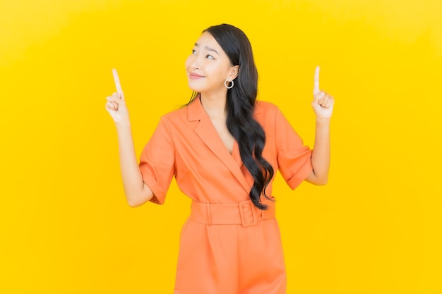 Portrait beautiful young asian woman smile with action on yellow