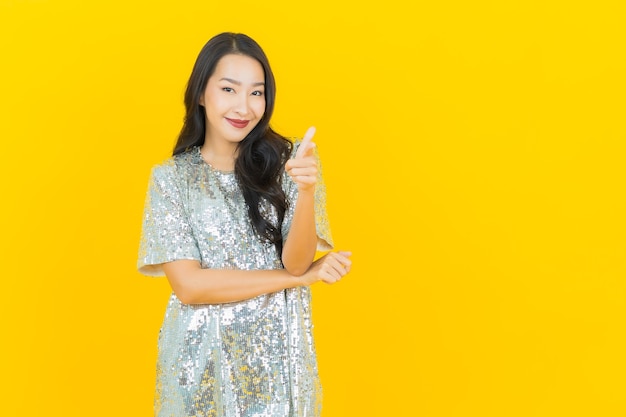 Portrait beautiful young asian woman smile with action on yellow