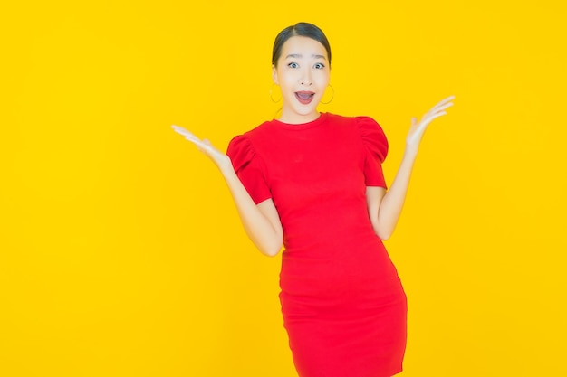 Portrait beautiful young asian woman smile with action on yellow