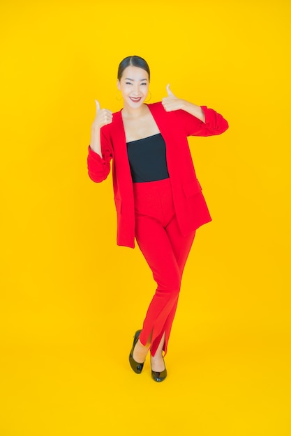 Portrait beautiful young asian woman smile with action on yellow