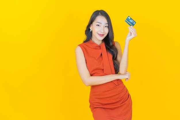 Portrait beautiful young asian woman smile with credit card on yellow