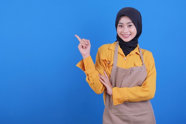 Portrait beautiful young asian woman wear apron pointing up left side