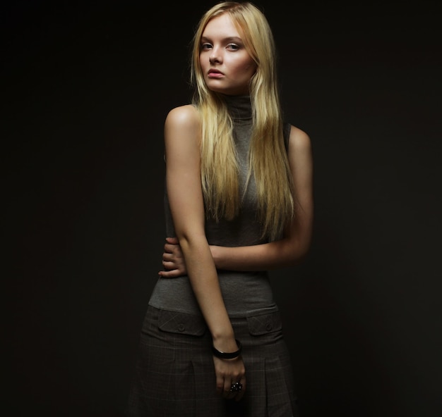 Portrait of beautiful young blonde girl in black dress