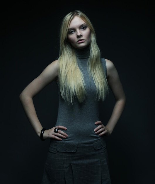 Portrait of beautiful young blonde girl over dark background Fashion photo