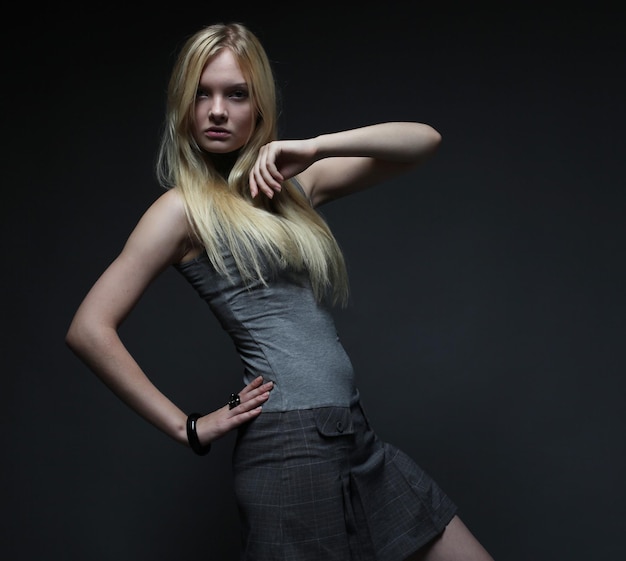 Portrait of beautiful young blonde girl over dark background Fashion photo