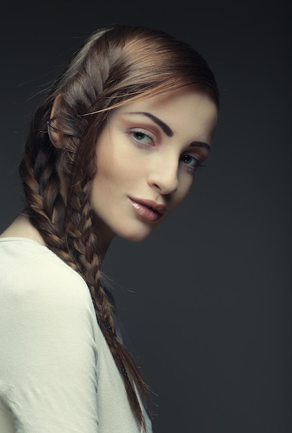 Portrait of beautiful young blonde woman with creative braids ha