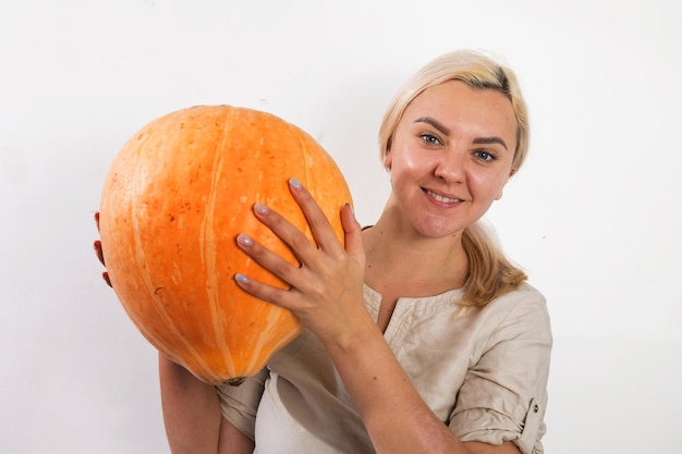 Portrait of beautiful young blonde woman with pumpkin ready for halloween celebration mockup for postcard and invitation or advertisement