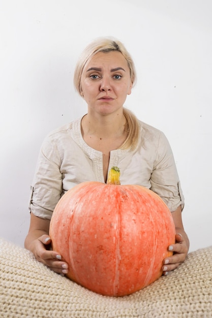 Portrait of beautiful young blonde woman with pumpkin ready for halloween celebration mockup for postcard and invitation or advertisement