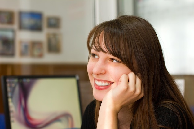 Portrait of a beautiful young brunette smiling girl in the office