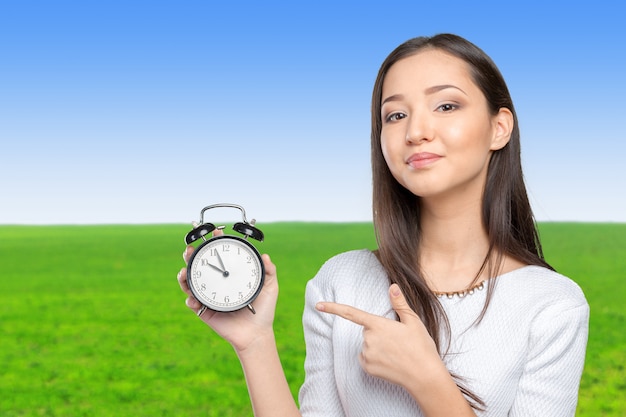 Portrait of beautiful young business woman holding a clock