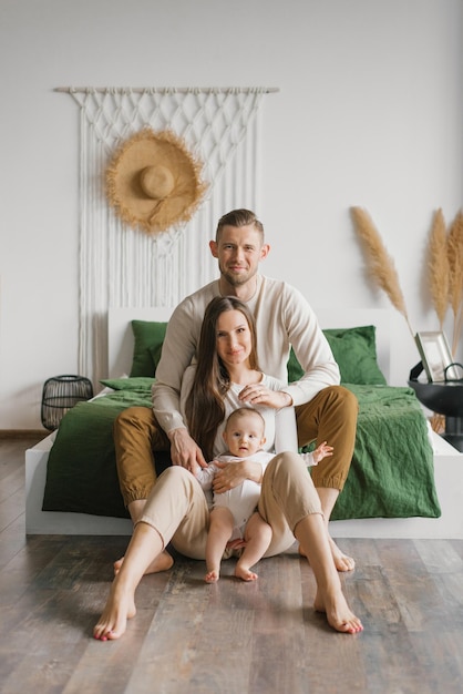 Portrait of a beautiful young family with a baby at home