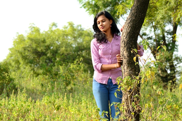 Portrait of beautiful young girl in park posing.