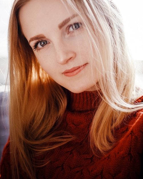 Portrait of a beautiful young girl in a red sweater