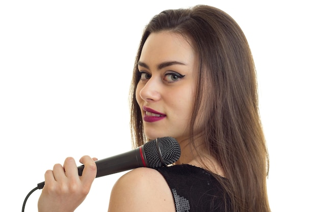 Portrait of a beautiful young girl that keeps the microphone and smiling closeup