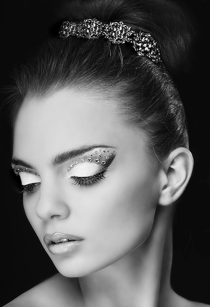 Portrait of beautiful young girl with fashion make-up isolated on black background