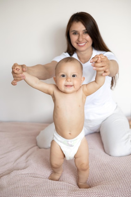 A portrait of a beautiful young mother and her sweet baby in a diaper Motherhood Happy family