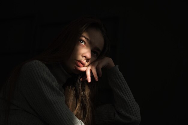 Portrait of beautiful young woman against black background