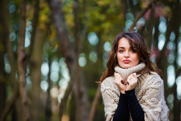 Portrait of beautiful young woman in autumn park. Enjoying autumn