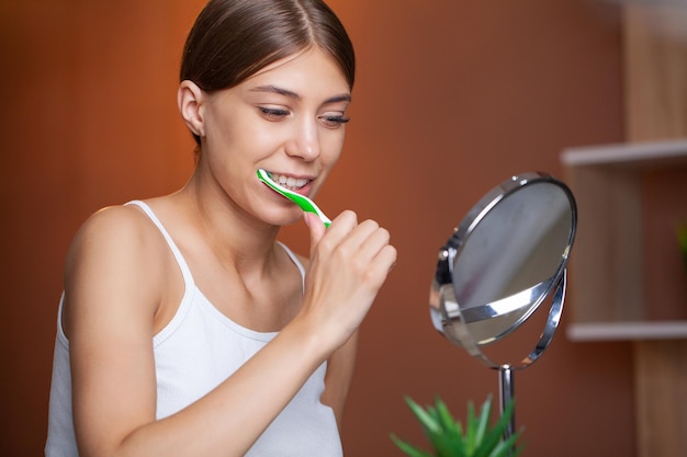 Portrait of beautiful young woman brushing teeth