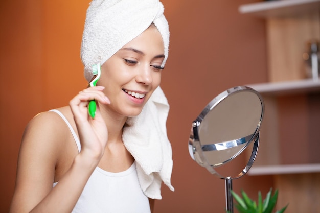 Portrait of beautiful young woman brushing teeth