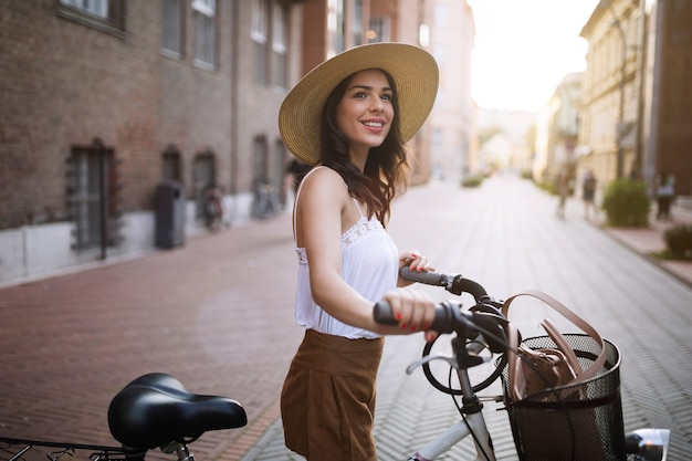 Portrait of beautiful young woman enjoying time on bicycle in urban area