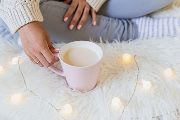 Portrait of a beautiful young woman holding a cup of hot coffee