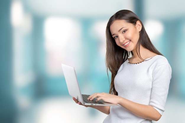 Portrait of beautiful young woman holding laptop isolated 