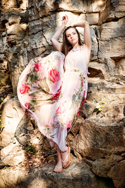 Portrait of a beautiful young woman on nature. Girl in a long dress in the rocks.