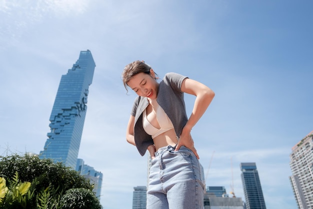 Portrait of beautiful young woman relaxing with city view wearing white bikini and long leg jeans