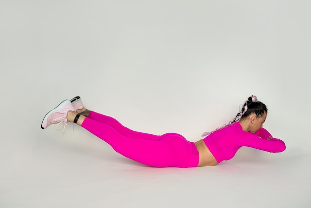 Portrait of a beautiful young woman in sportswear working out in a stretching studio