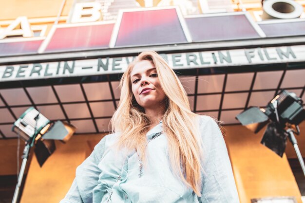 Photo portrait of beautiful young woman standing against building in city