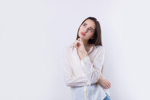 Portrait of a beautiful young woman thinking isolated on white background