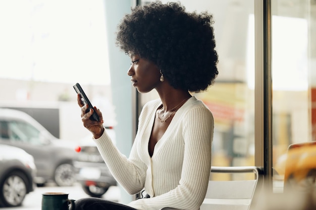 Portrait of a beautiful young woman using her cellphone in a cafe