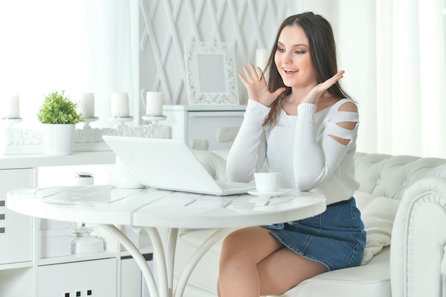 Portrait of beautiful young woman using modern laptop at table