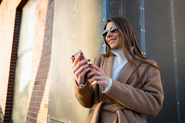 Portrait of beautiful young woman using smartphone outdoors