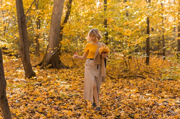 Portrait of beautiful young woman walking outdoors in autumn. Fall season and stylish girl concept.