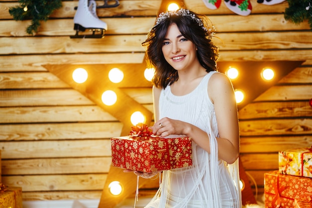 Portrait of a beautiful young woman who holds a gift for new year and Christmas.