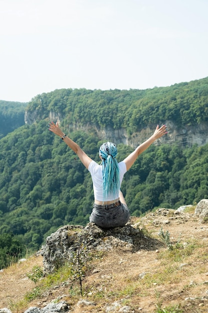 portrait of beautiful young woman with afro locks hiking in mountains freedom tranquility concept