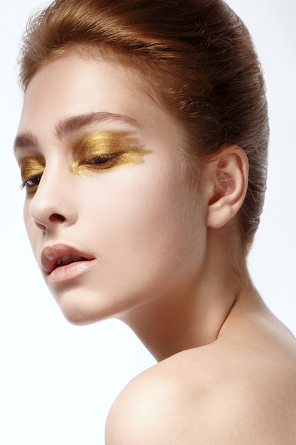 Portrait of Beautiful Young Woman with bright golden make-up