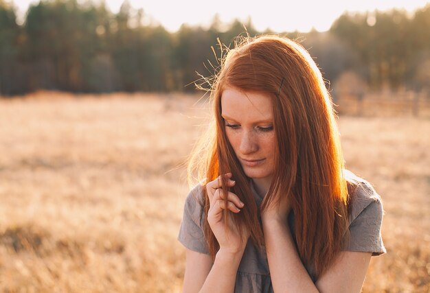 Portrait of Beauty Teenage Model Girl with Red Hair on the Background of Nature