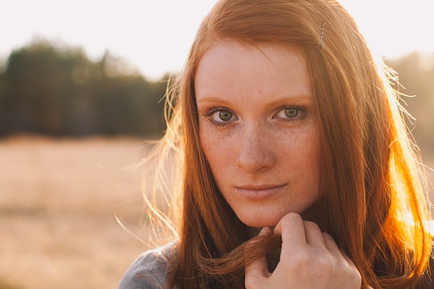 Portrait of Beauty Teenage Model Girl with Red Hair on the Background of Nature